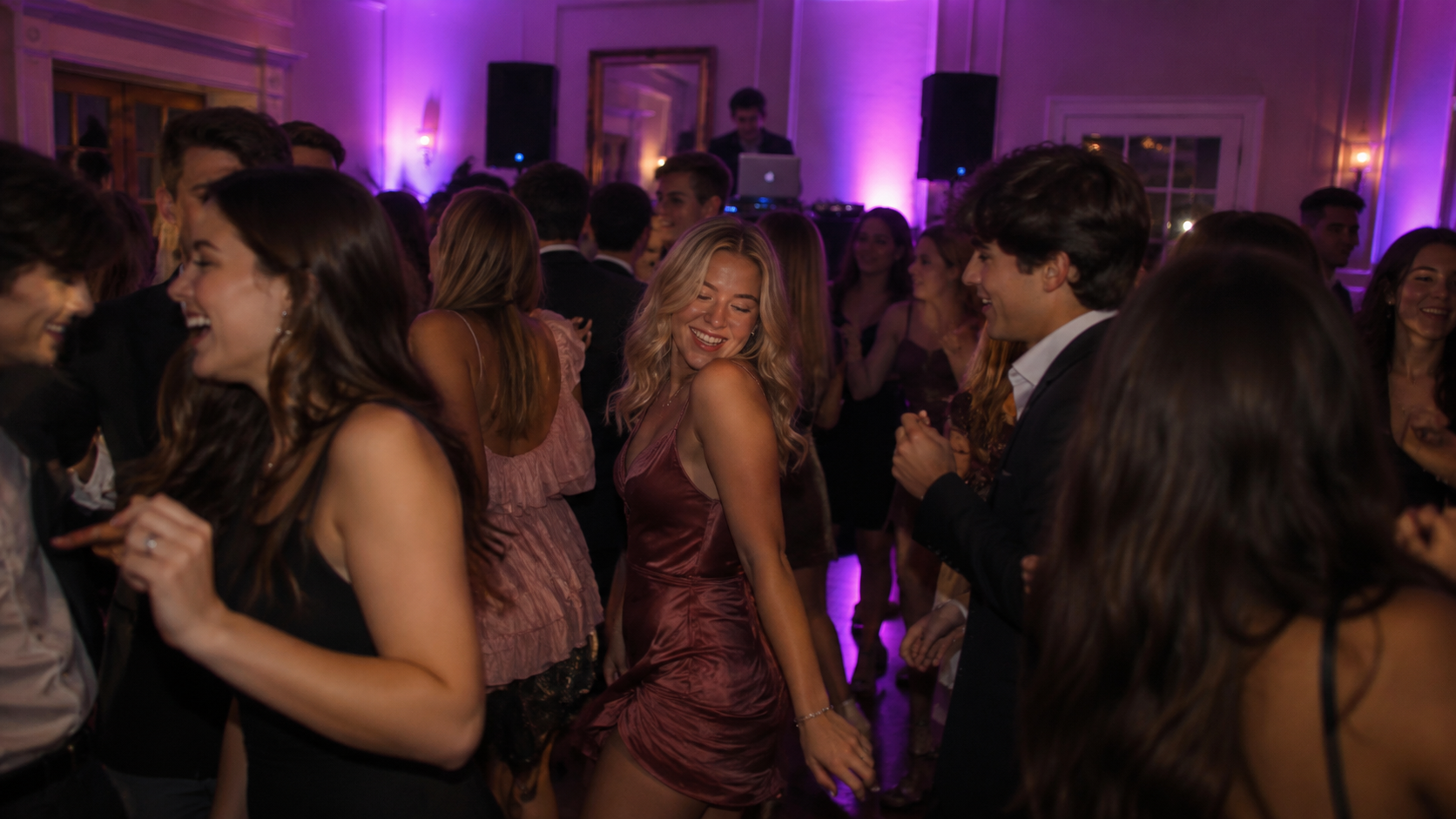 Sorority date party chapter room with pink and lavender uplighting, DJ setup, and couples dancing at Auburn University Greek event